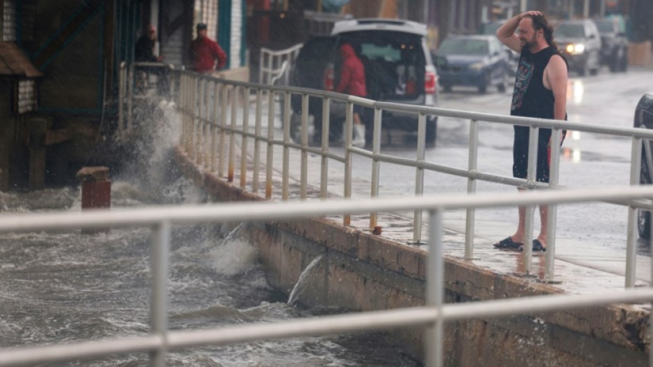 A rain-soaked man in Cedar Key, Florida observes waves kicked up by the winds of Tropical Storm Debby, which is strengthening as it moves through the Gulf of Mexico on August 04, 2024 