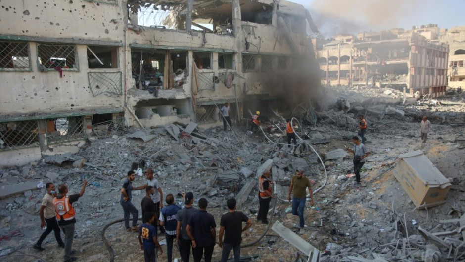 Palestinian rescuers extinguish a fire after Israeli bombardment hit a school complex in the Gaza City area on August 3, 2024