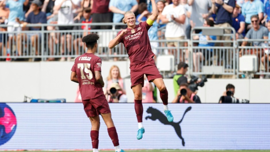 Manchester City forward Erling Haaland, right, celebrates after scoring his second goal against Chelsea in a pre-season English club friendly at Columbus, Ohio