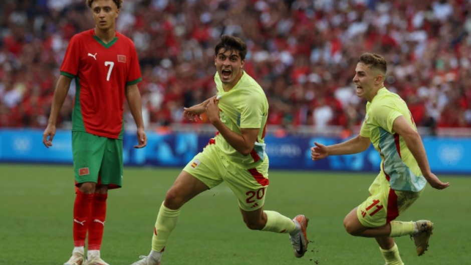 Juanlu Sanchez (C) celebrates with Fermin Lopez after scoring Spain's winning goal against Morocco in their Olympic men's football semi-final