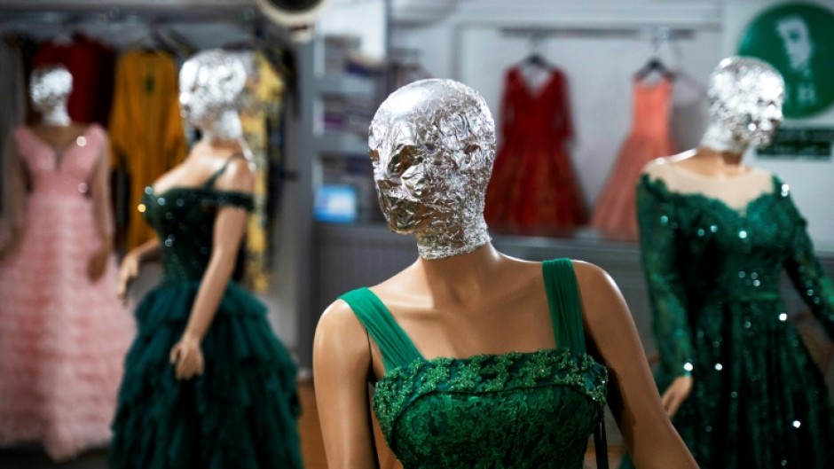 To comply with the Taliban government's edict, shopkeepers in Kabul hide the mannequins' faces in foil