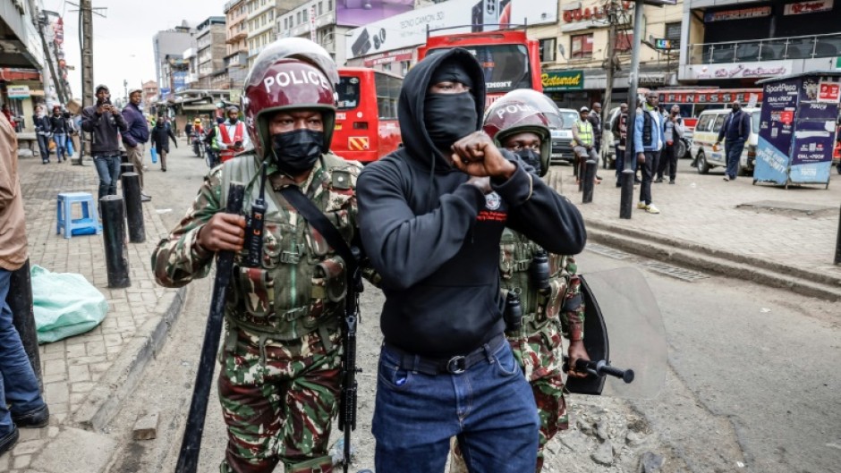 Kenyan police detain a protester in the capital Nairobi