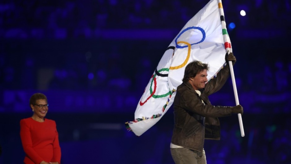 Tom Cruise takes the Olympic flag as Karen Bass, the mayor of 2028 hosts Los Angeles, looks on