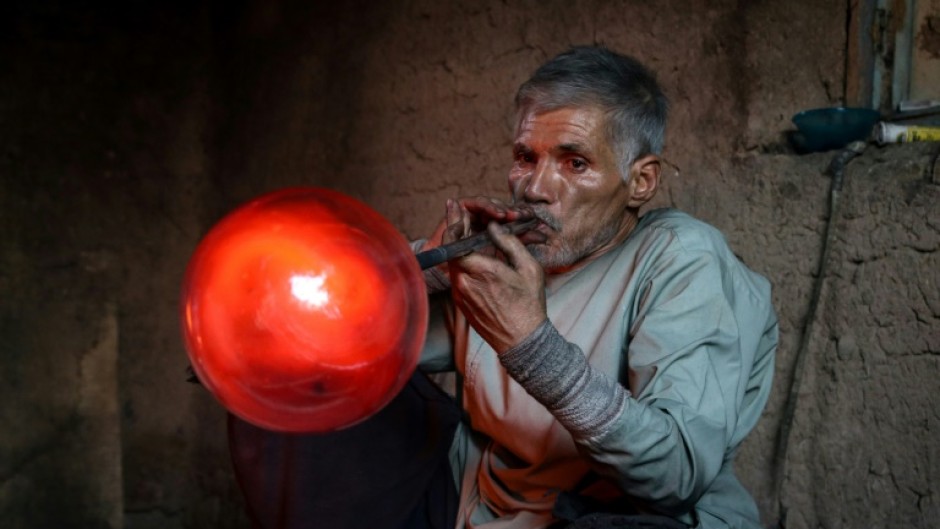 Afghan glassblower Ghulam Sakhi Saifi crafts glassware at his traditional workshop in the western city of Herat