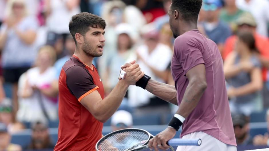 Spain's Carlos Alcaraz, left, shakes hands with Gael Monfils after falling to the Frenchman at the ATP and WTA Cincinnati Open