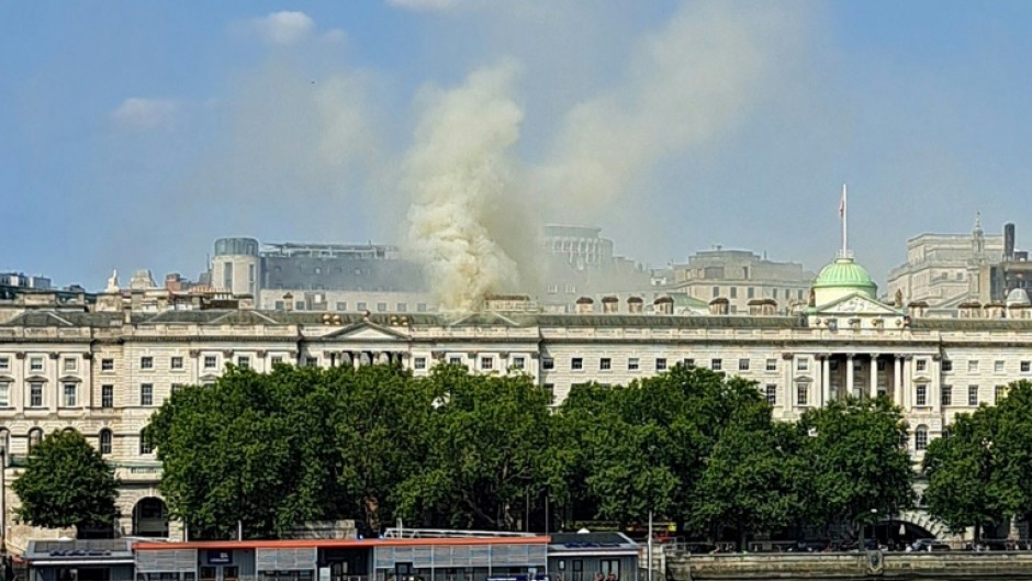 Smoke rises from a fire located in the roof of Somerset House beside the River Thames