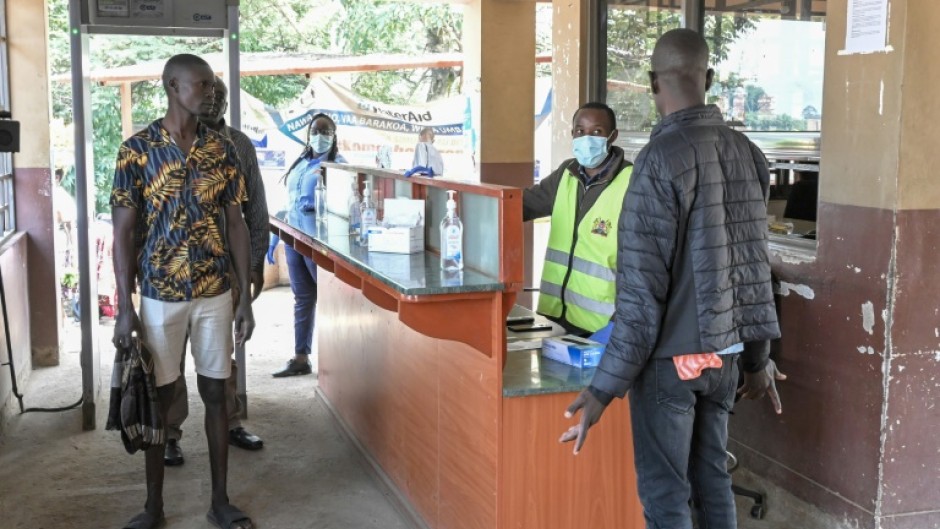 A port health officer screens travellers at a border crossing point between Kenya and Uganda