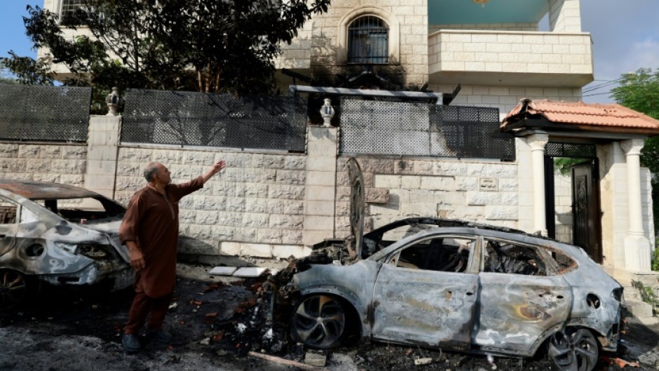 A man points to damage in his house after an attack by Jewish settlers on the Palestinian village of Jit, near Nablus, in the Israeli occupied West Bank 