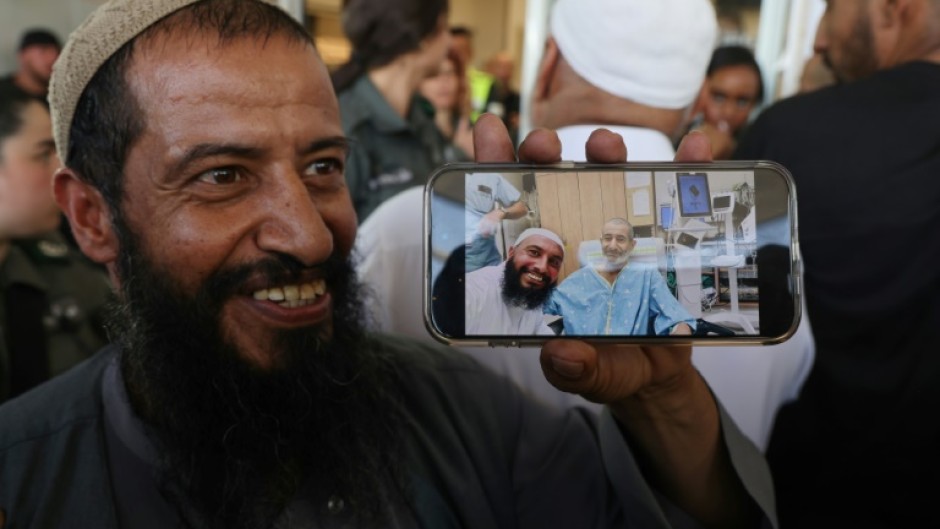 The brother of freed Israeli hostage Kaid Alkadi shows a mobile phone picture of him with another brother