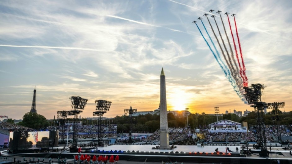 Jets from the French Air Force acrobatic flying team fly over Place de la Concorde during the Paralympics opening ceremony