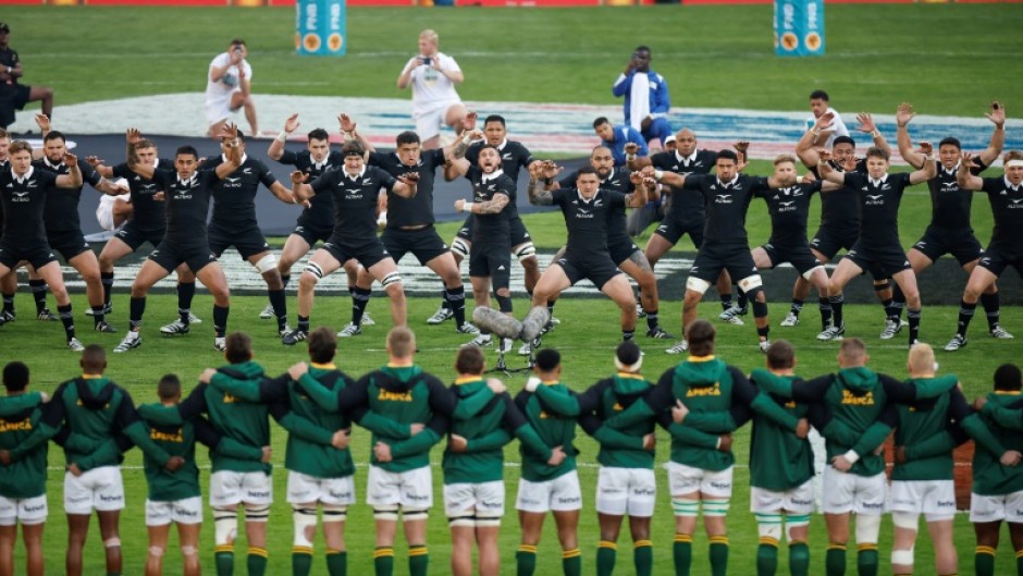 New Zealand players (background) perform the Haka watched by the South African team ahead of a Rugby Championship match in Johannesburg on August 31.
