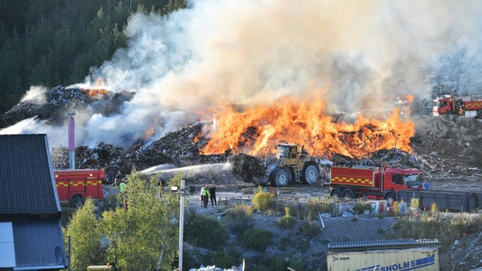 Firefighters tackle a blaze at a Think Pink landfill site at Botkyrka, south of Stockholm