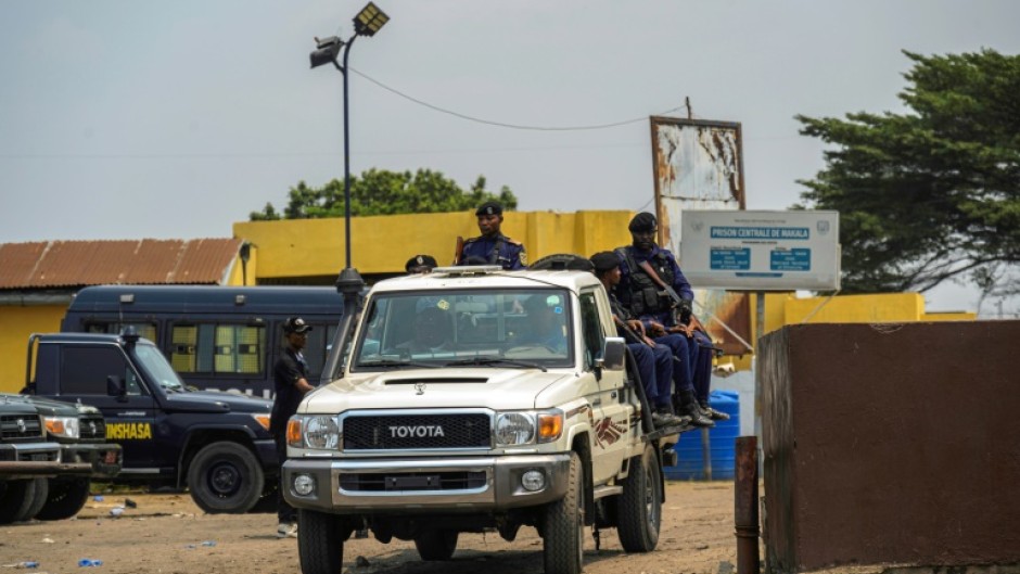 A police vehicle with officers leaves the Makala prison 