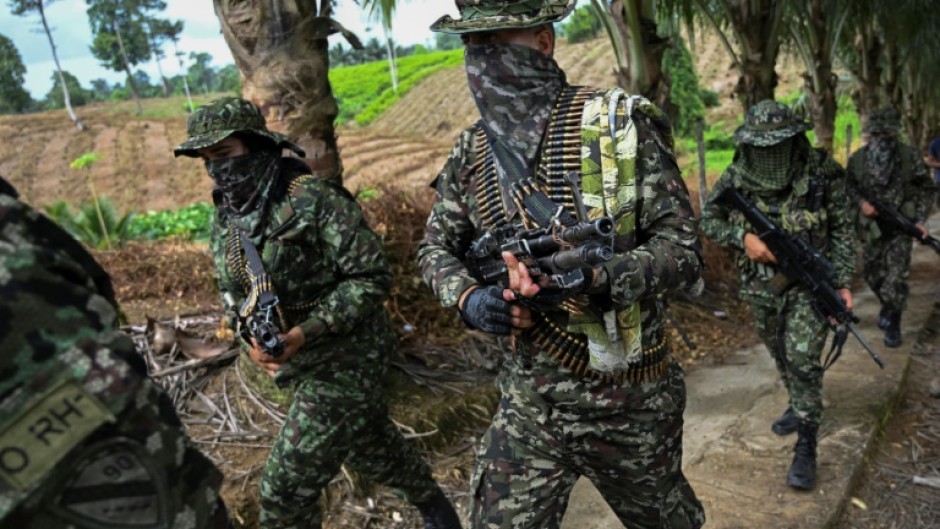 Members of the FARC dissident group Segunda Marquetalia march on a farm in Llorente, Colombia in August 2024