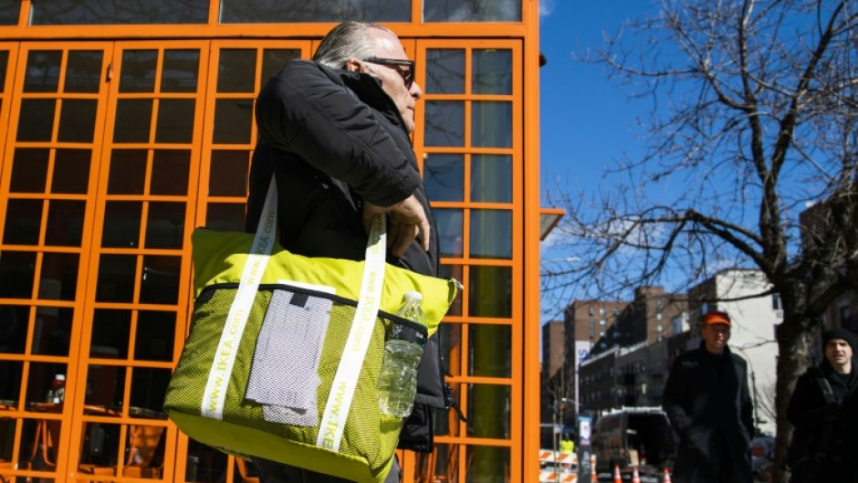 A customer carries his own reusable bag after shopping at a local supermarket on March 1, 2020 in New York City