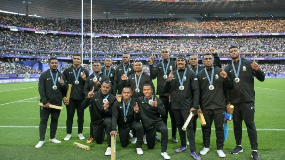 The Fiji team celebrate with their silver medals at the Stade de France following defeat to France in the final of the Paris Olympics