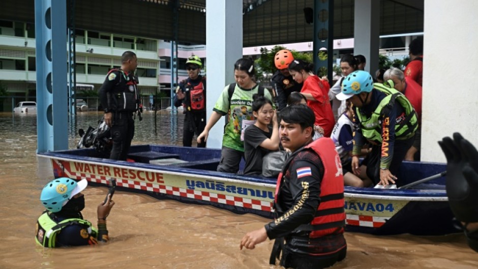 Local rescue teams pick up schoolchildren who were trapped overnight during flooding in the northern Thai city of Chiang Rai on September 12