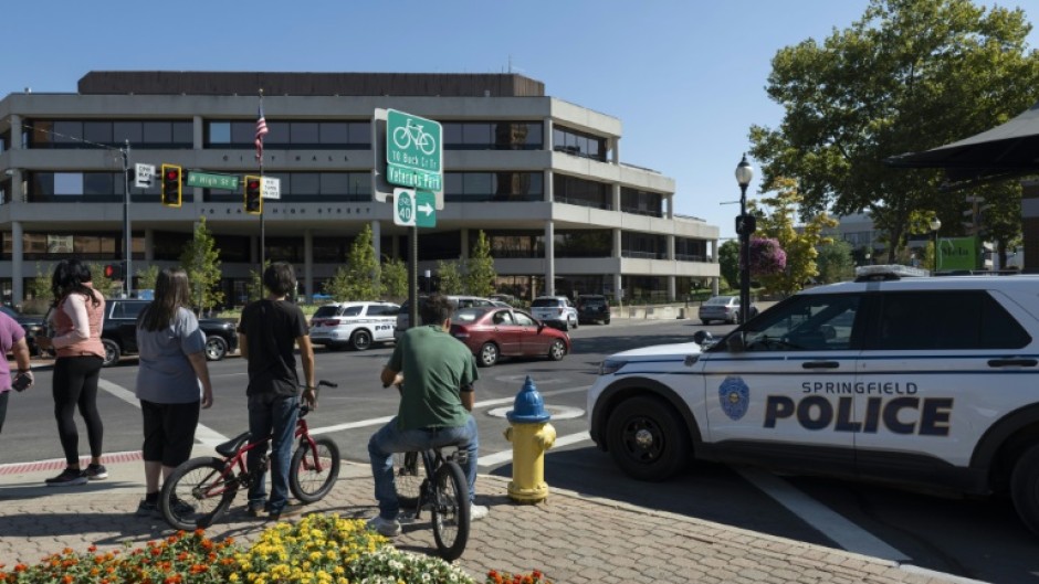 People watch as Springfield Police Department officers investigate the Springfield City Hall after bomb threats