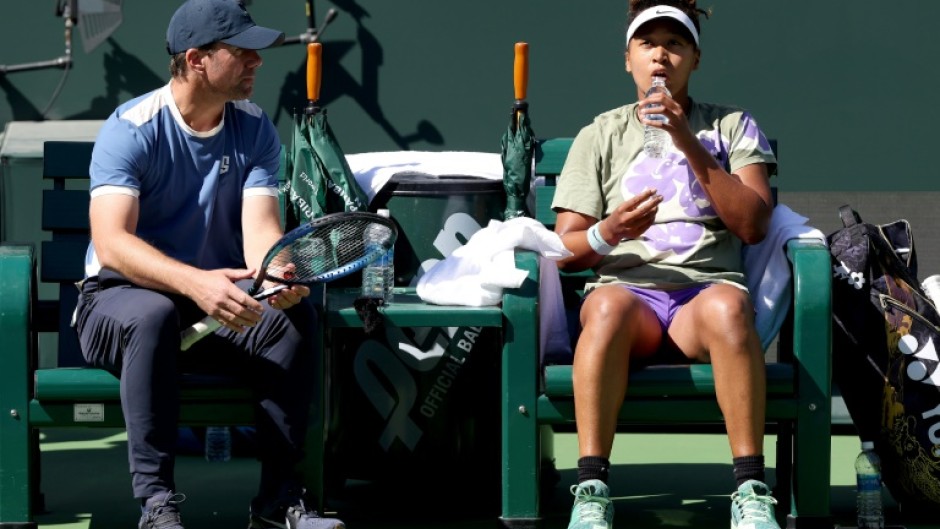 Former world number one Naomi Osaka of Japan confers with coach Wim Fissette while training at Indian Wells