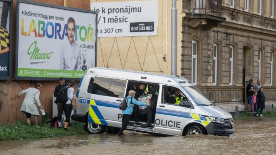 Police officers evacuate people at a flooded street in Opava, Czech Republic during storm Boris