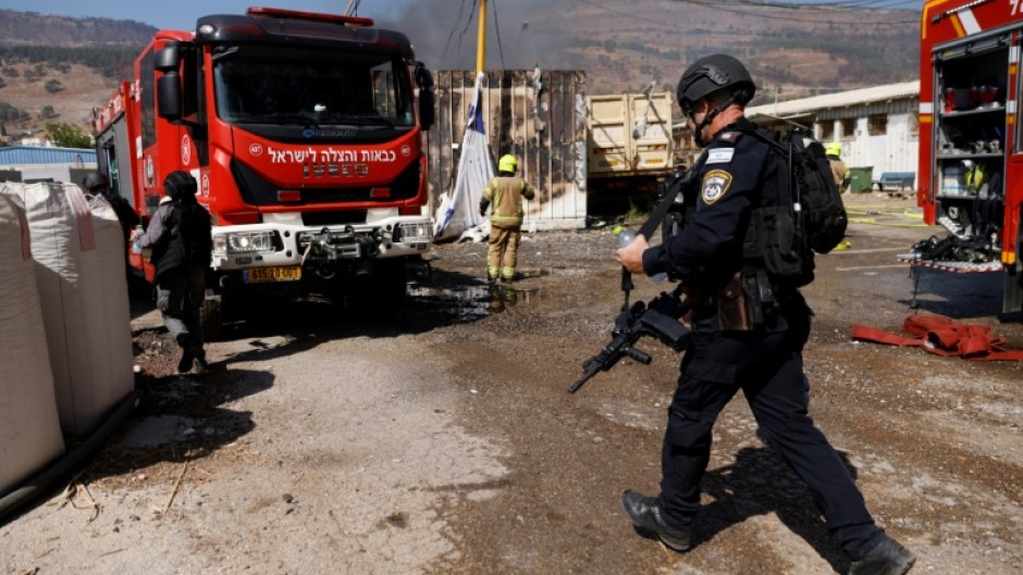 Israeli emergency services respond to a blaze in the border town of Kiryat Shmona ignited by rocket fire from Lebanon