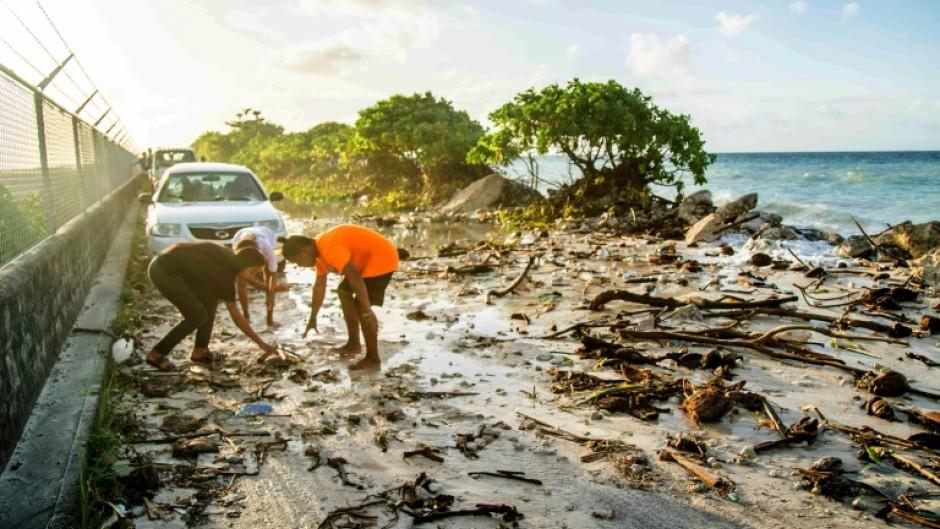 A photo taken on December 6, 2021 shows high-tide flooding and debris covering the road to the airport in the Marshall Islands capital Majuro