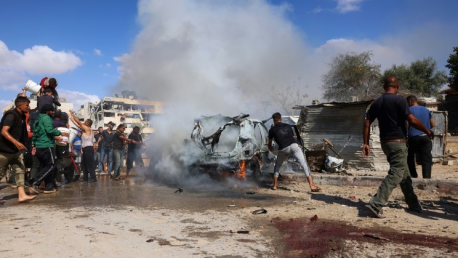 Palestinians at the site of an Israeli strike in Gaza's southern Khan Yunis on October 1