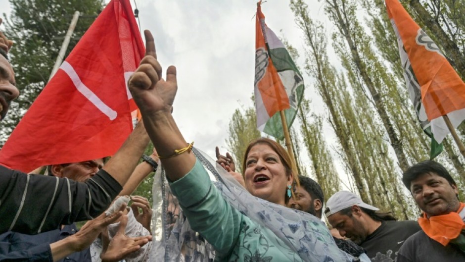 Supporters of Jammu and Kashmir National Conference party and Indian National Congress party wave flags during celebrations outside a counting centre