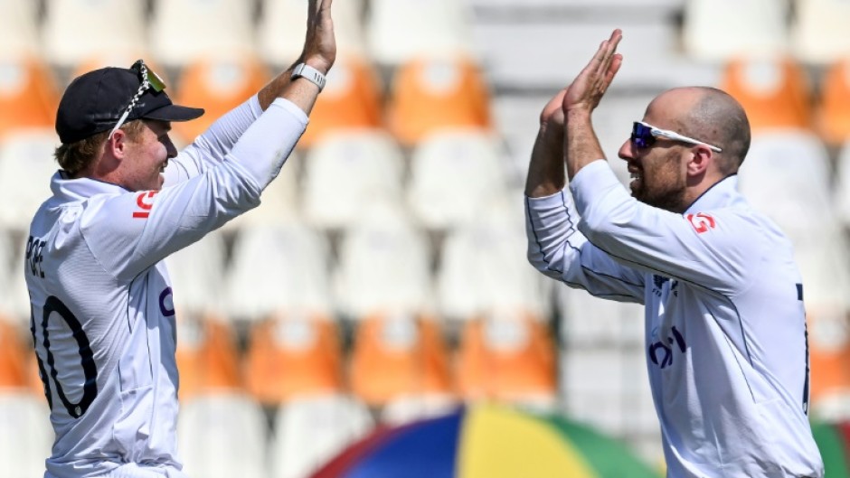 England's captain Ollie Pope celebrates with teammate Jack Leach (R) after winning the first Test cricket match against Pakistan 