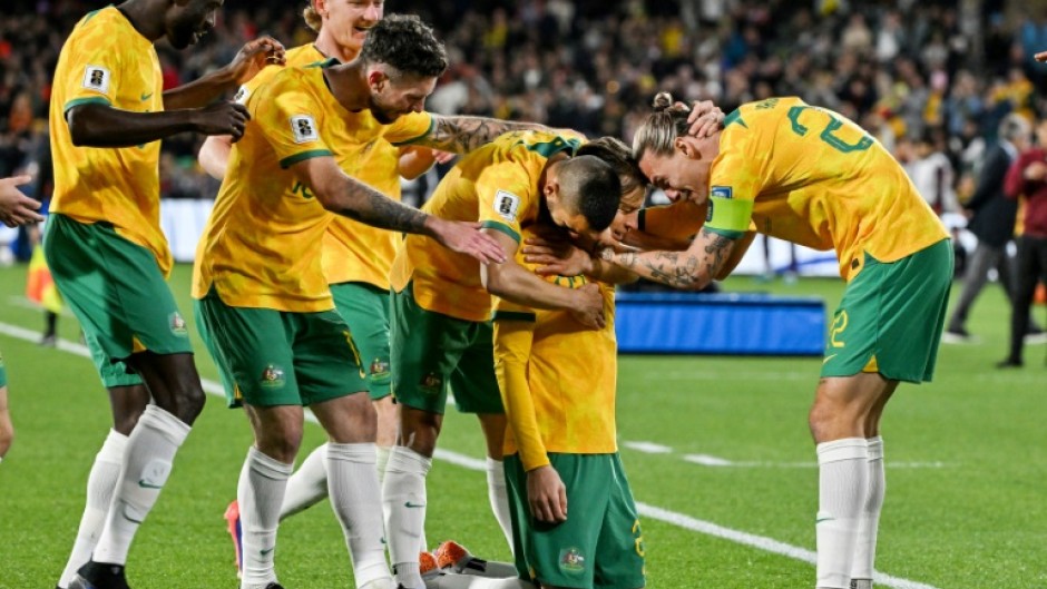 Australia's Craig Goodwin (kneeling) celebrates scoring against China 