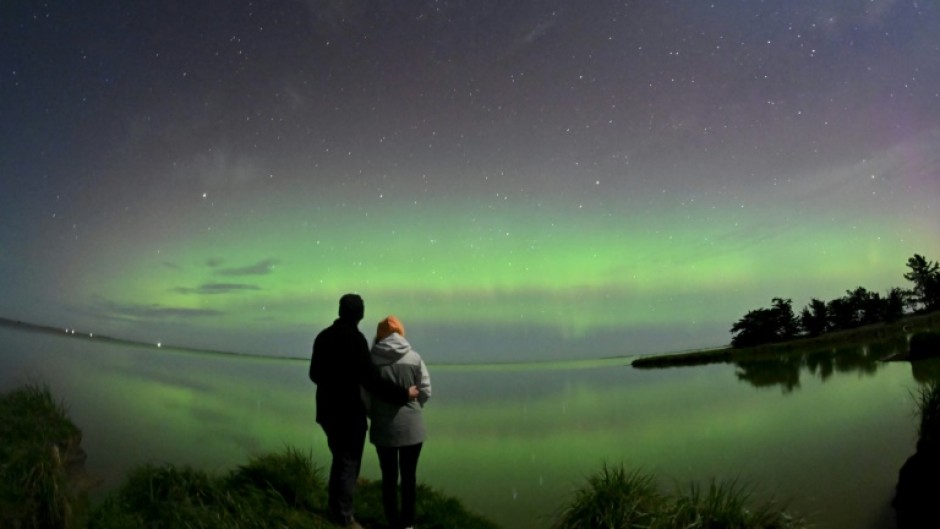 A couple looks out at the southern lights on the outskirts of Christchurch in New Zealand