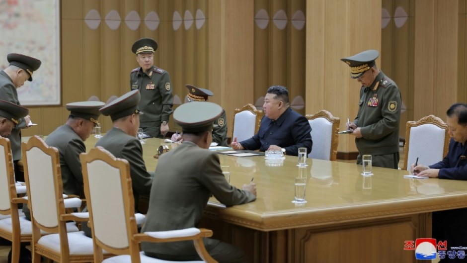 A picture released by North Korea's official Korean Central News Agency  via KNS shows Kim Jong Un (centre) at Monday's security meeting at an undisclosed location