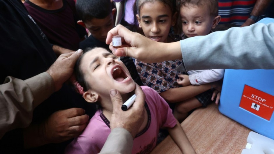 Palestinian children receive drops as part of a polio vaccination campaign in Deir al-Balah in the central Gaza Strip