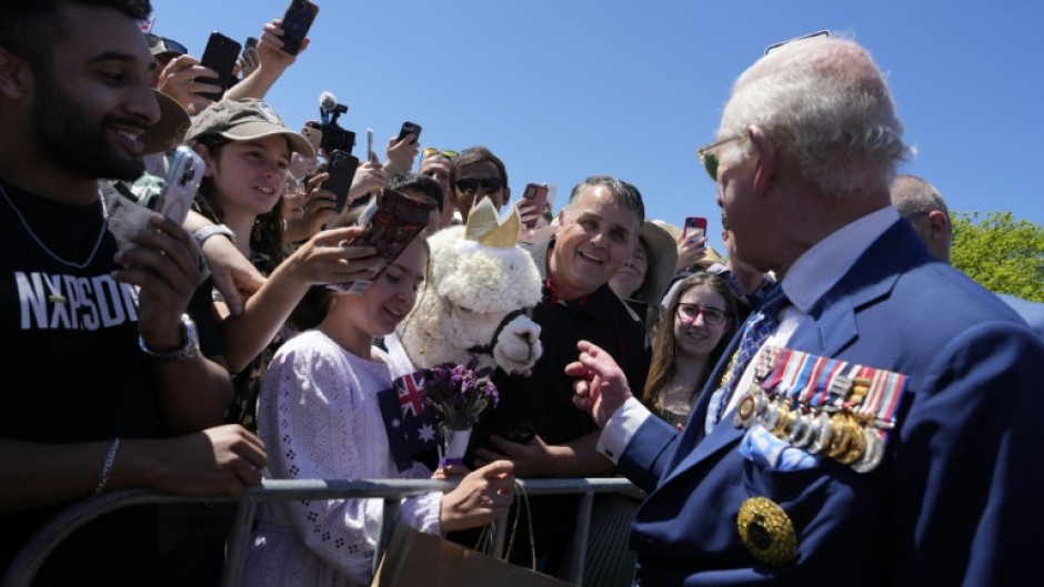 Britain's King Charles III chats with the owner of an alpaca named Hephner before leaving the Australian War Memorial in Canberra on October 21, 2024.