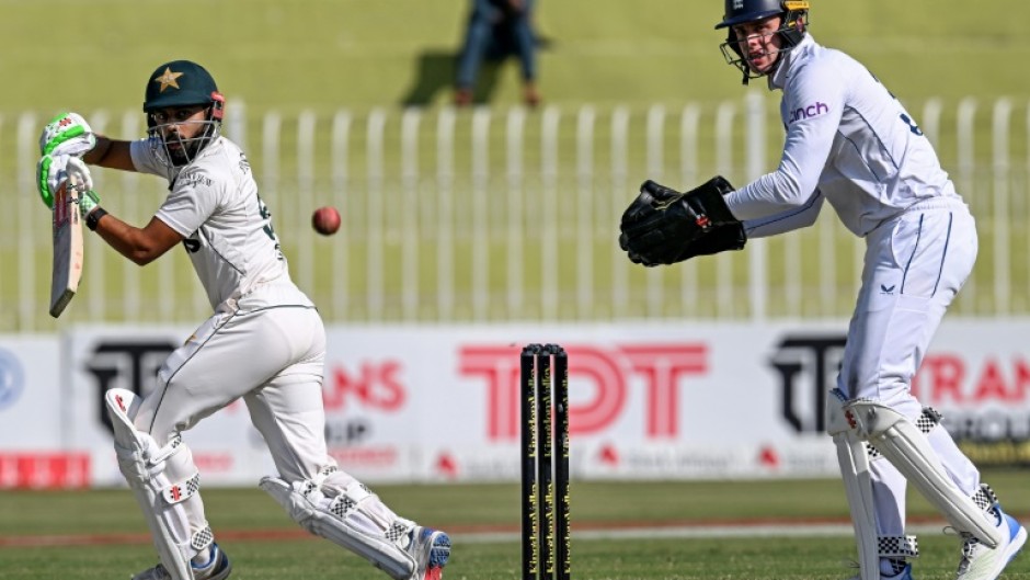 Pakistan's Saud Shakeel (L) plays a shot as England's wicketkeeper Jamie Smith looks on during the second day of the third and final Test