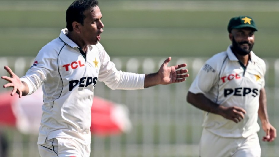 Pakistan's Noman Ali (L) celebrates after taking the wicket of England's captain Ben Stokes 