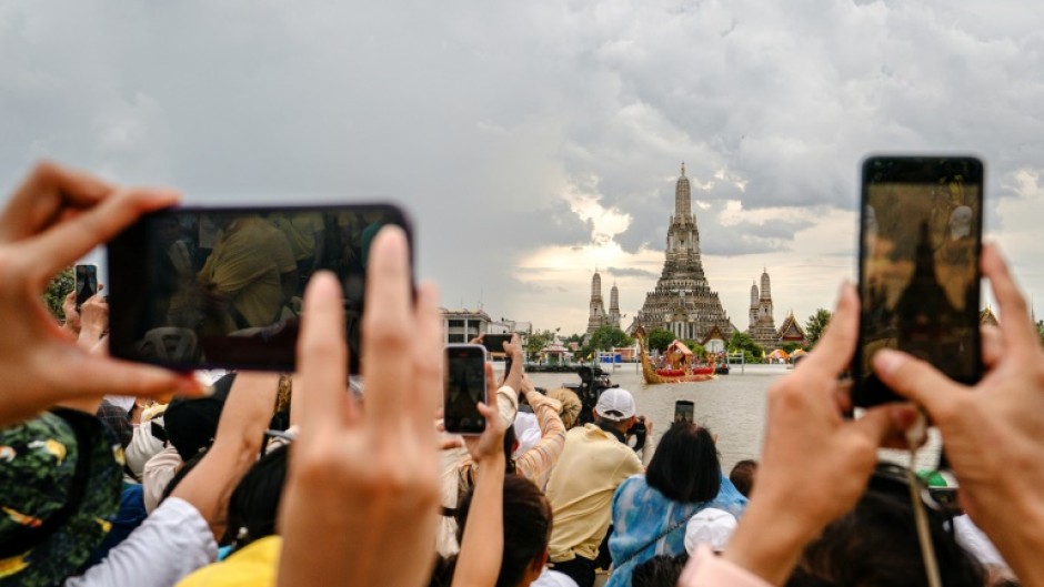 Spectators watch the Royal Barge Procession on the Chao Praya River