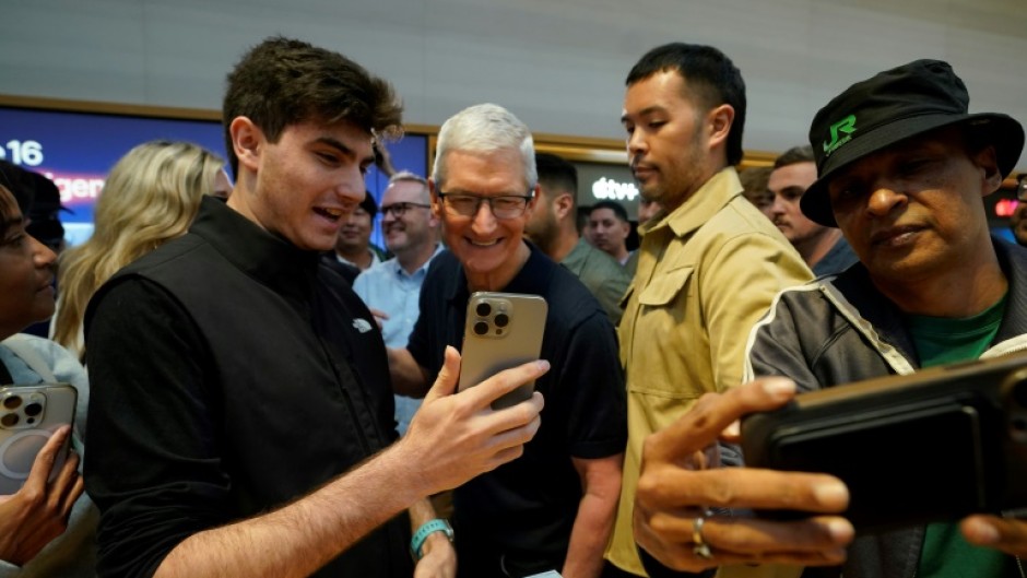 Apple CEO Tim Cook (C) is pushing the company into the AI era