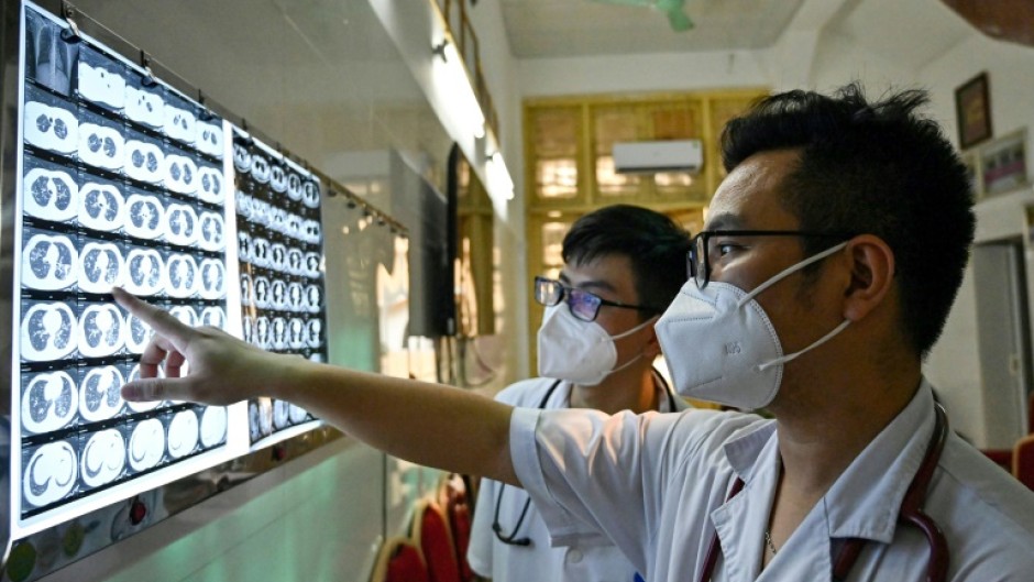 A Vietnamese doctor and his colleague check X-rays of a drug-resistant tuberculosis patient at the National Lung Hospital in Hanoi