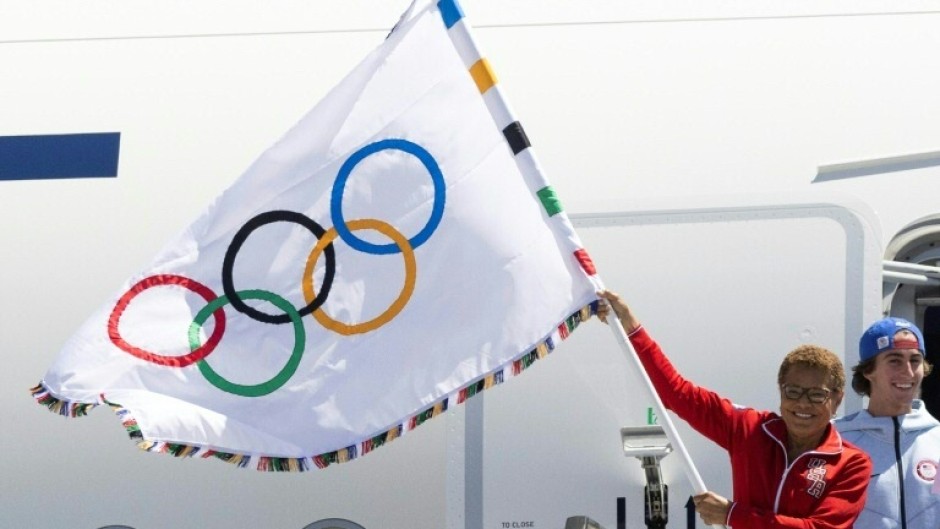 Los Angeles Mayor Karen Bass, whose city will host the 2028 Summer Games, holds the five-ringed Olympic banner