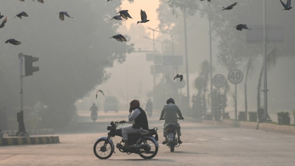 Commuters make their way amid smog in Lahore 