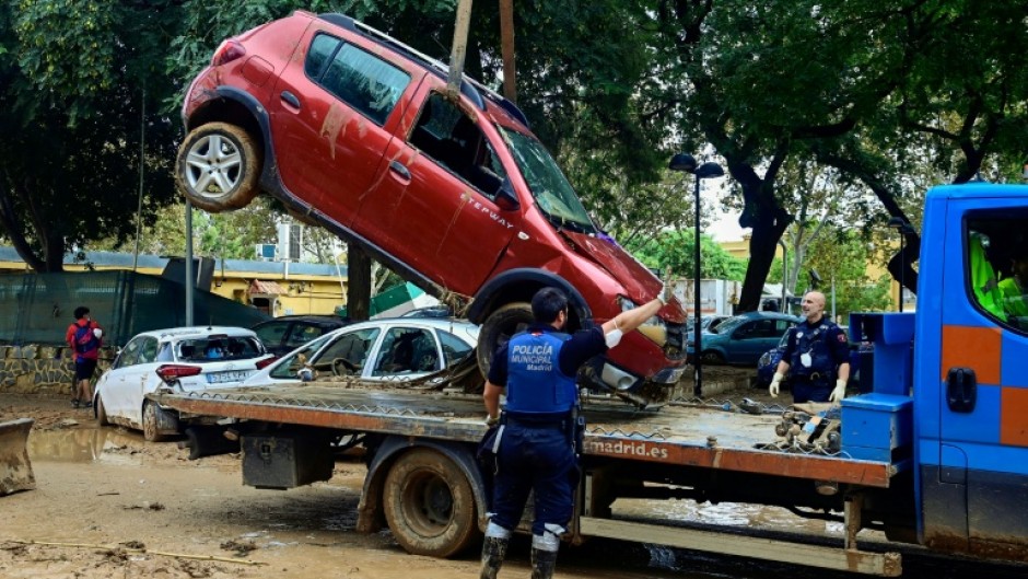 Police remove flood-damaged cars in Alfafar, in the region of Valencia