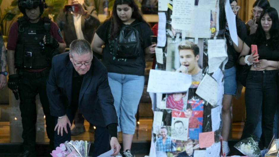 Geoff Payne (L), the father of One Direction pop singer Liam Payne, looks at a note placed by fans paying tribute to his late son outside the CasaSur Hotel in Buenos Aires on October 18, 2024