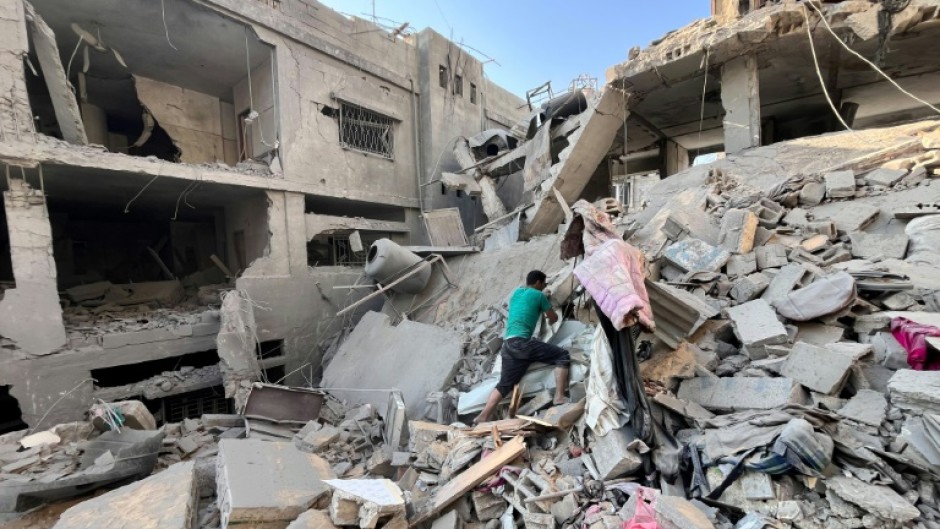 A Palestinian searches for relatives under rubble of building bombed by Israel in Beit Lahia