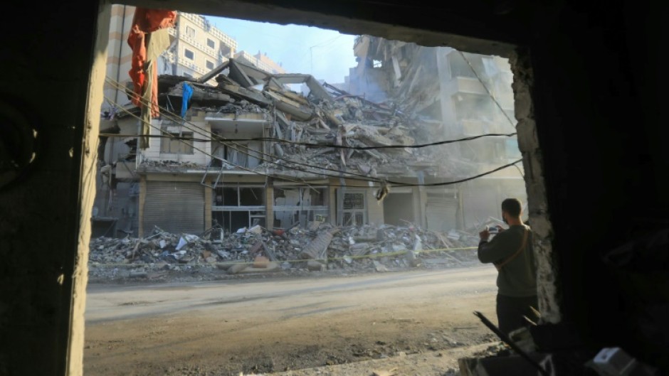 A man snaps a picture of a building hit by an Israeli strike, during a media tour organised by Hezbollah in Beirut's southern suburbs