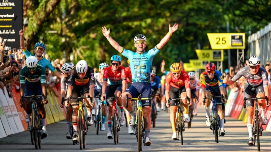 One last wave: Mark Cavendish (C) celebrates as he crosses the line to win his farewell race, the  Singapore Criterium 