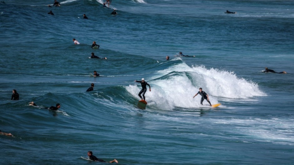 Surfers ride and paddle their boards at Maroubra Beach in Sydney last month