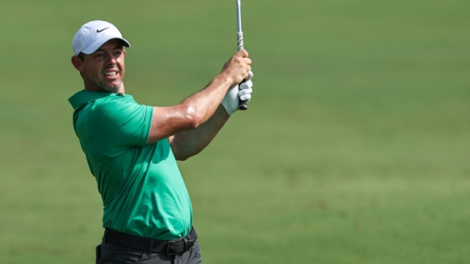 Out in front: Rory McIlroy eyes the ball after playing a shot on the first hole 