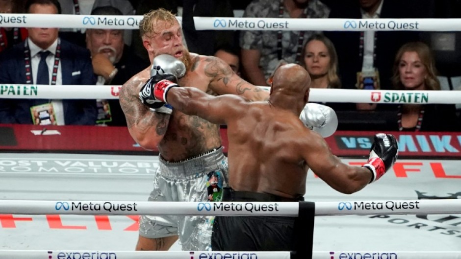 Jake Paul (left) backs Mike Tyson onto the ropes in their eight-round fight in Texas on Friday