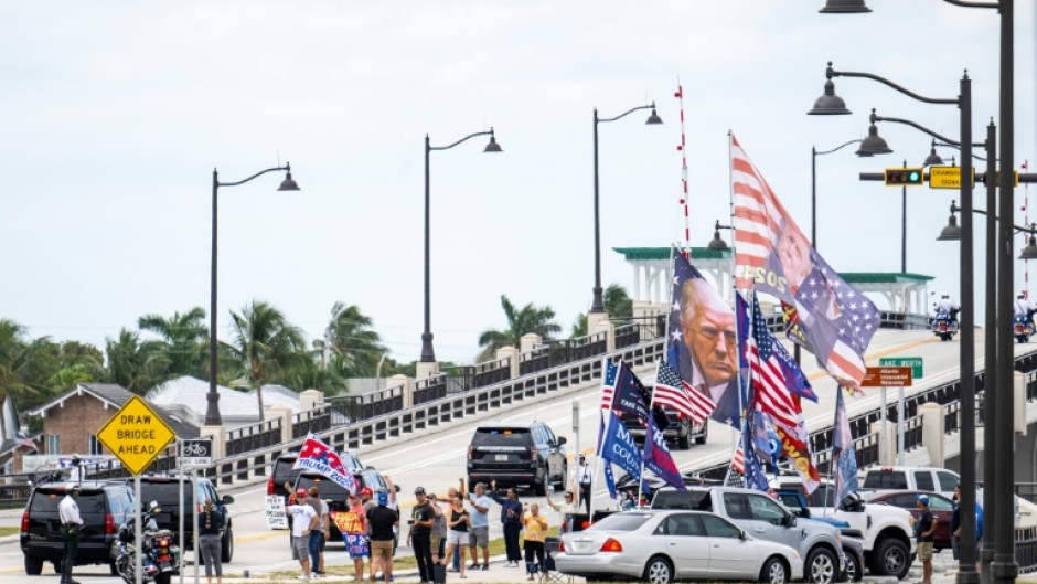 Supporters watch as the motorcade carrying US President-elect Donald Trump departs Mar-a-Lago in Palm Beach, Florida